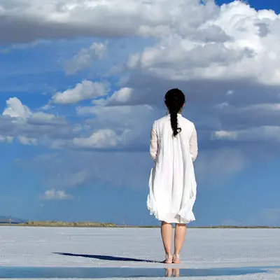 Woman on beach under blue sky